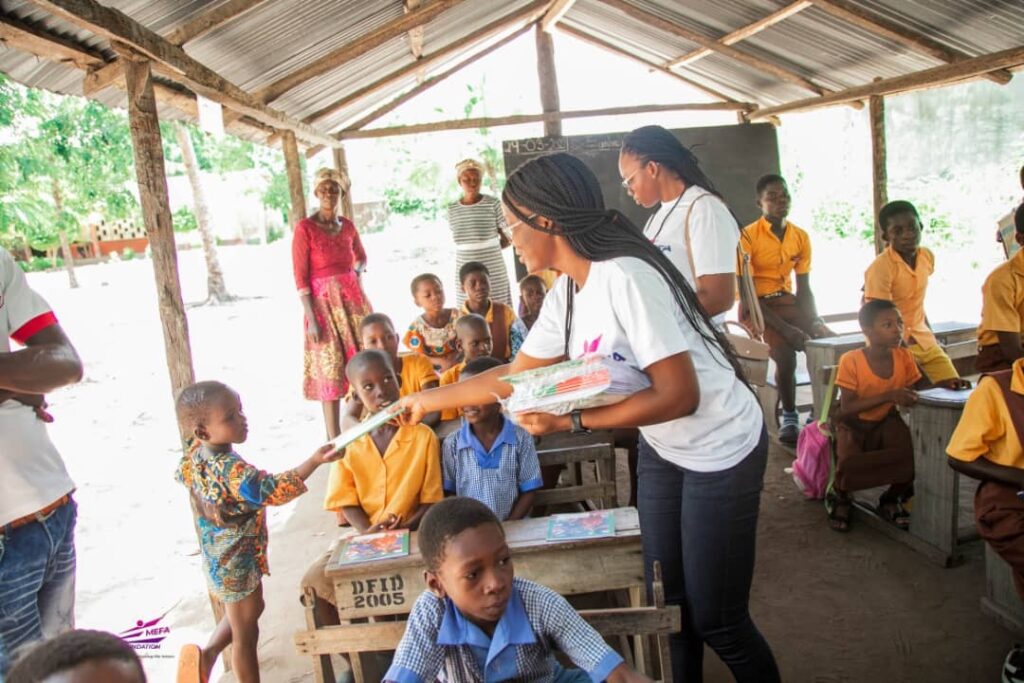 A woman handing something to another person in front of some kids.