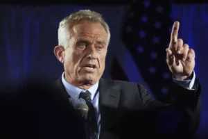 A man in suit and tie talking to someone.